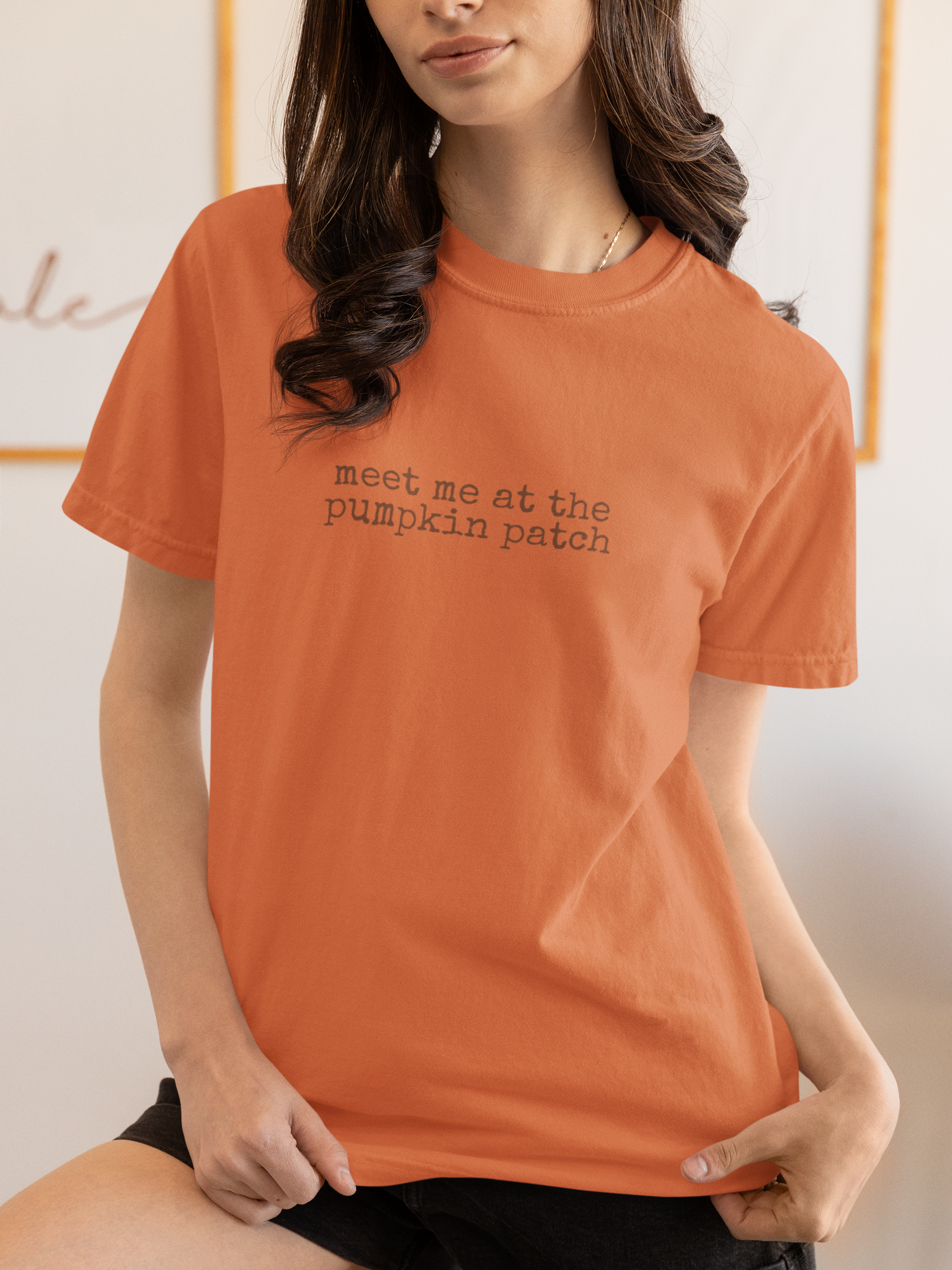 Person wearing an orange t-shirt with 'meet me at the pumpkin patch' text.