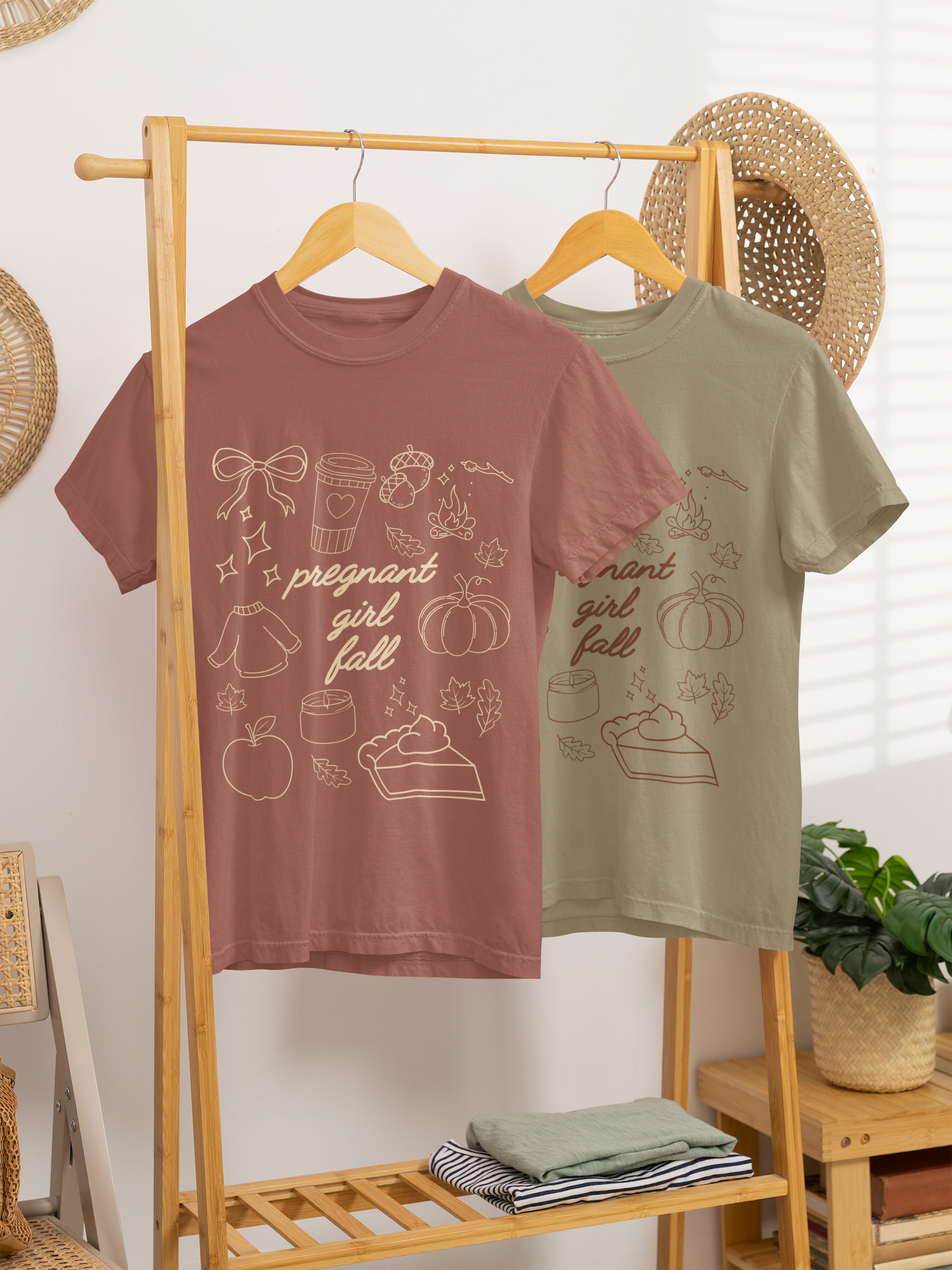 Two t-shirts, one brown and one green, hanging on a wooden rack with decorative items in the background.