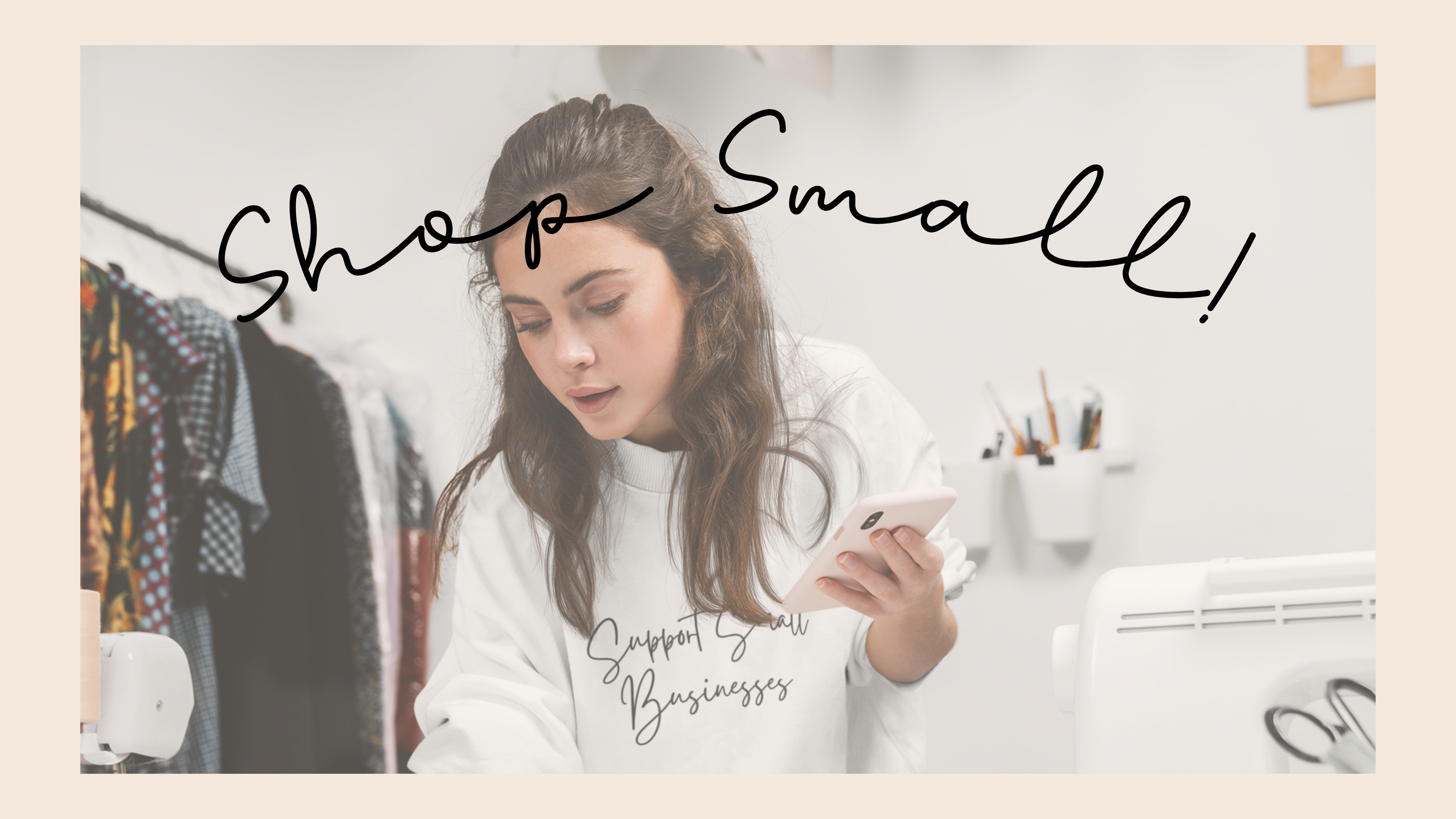 Woman wearing a 'Support Small Businesses' crewneck sweatshirt while working at her desk, promoting small business support.