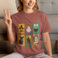 Person wearing a brown t-shirt with Halloween-themed designs, sitting on a couch.