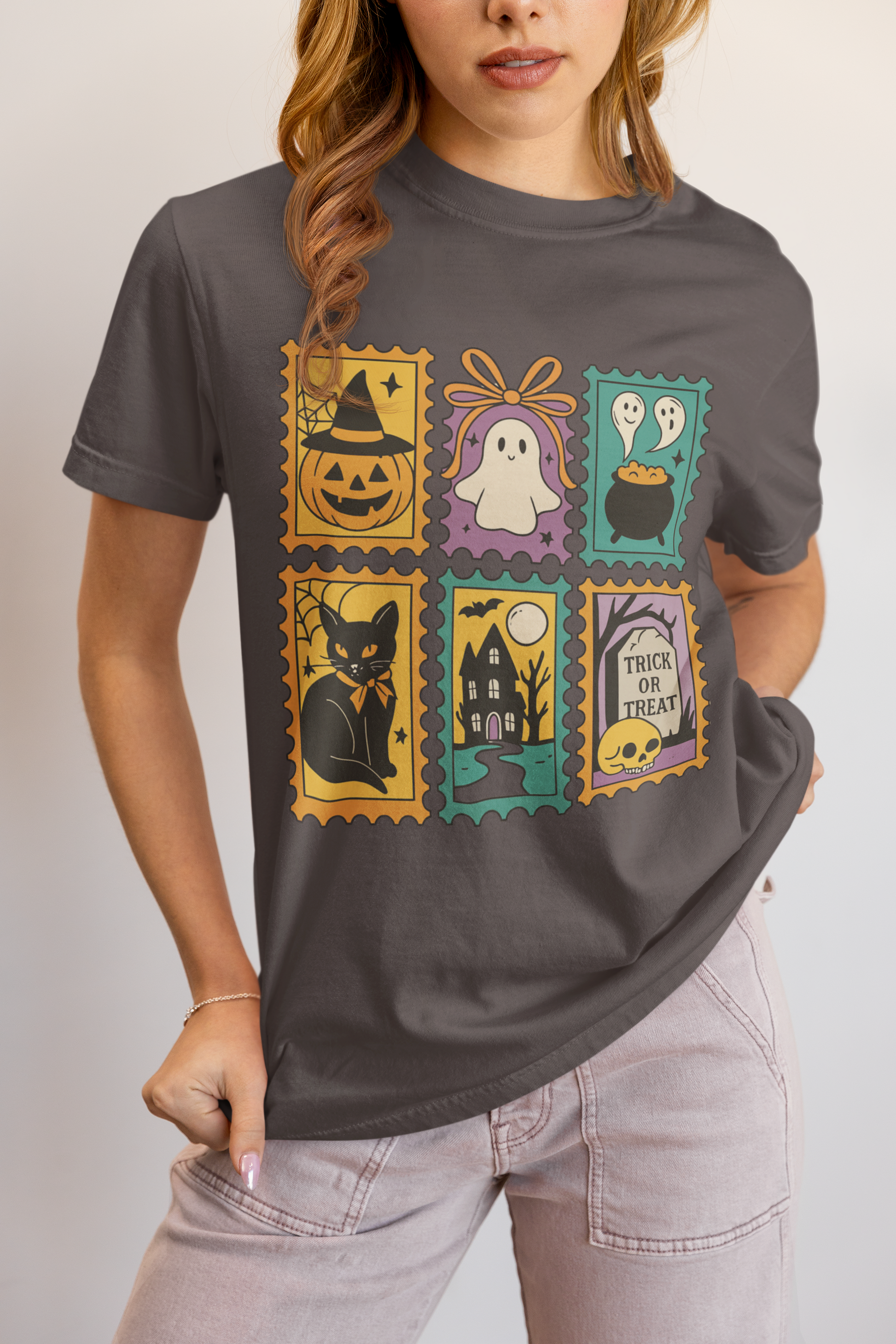 Person wearing a dark gray t-shirt with Halloween-themed postage stamp designs.