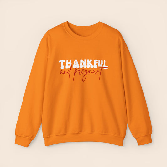 An orange crewneck sweatshirt with the text 'THANKFUL AND PREGNANT' printed.